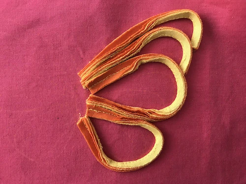 Both wings of butterfly applique are sewn to base fabric.