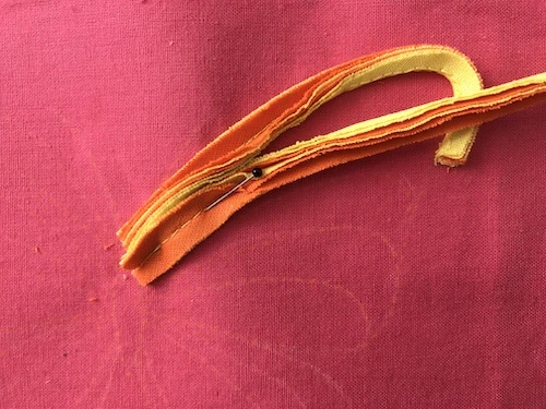 Second part of butterfly wing pinned to base fabric.