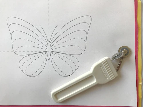 Butterfly pattern prepared for tracing with tracing wheel and tracing paper.