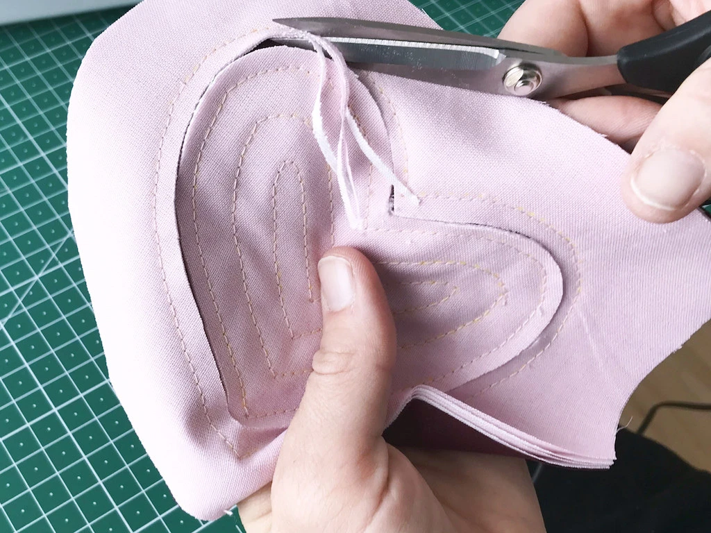 Cutting out thin stripes of stacked fabric with embroidery scissors.