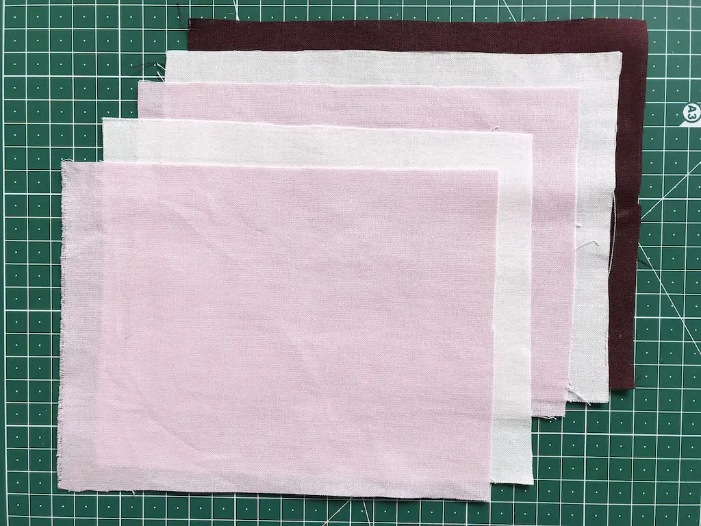 Stack of fabric rectangles prepared for faux chenille heart applique.