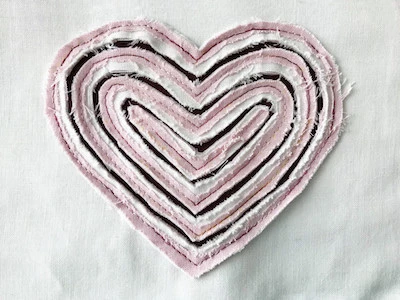 Variation of faux chenille style heart applique with a multi color thread topstitching.