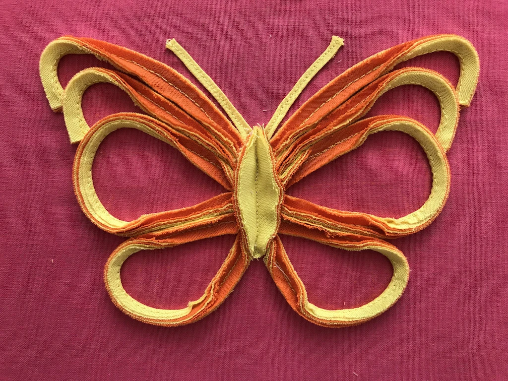 Finished butterfly sewn to a tunic.