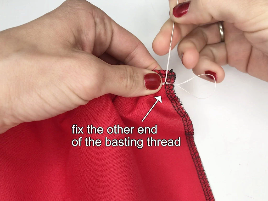 Fixing one end of basting thread to gathered fabric.