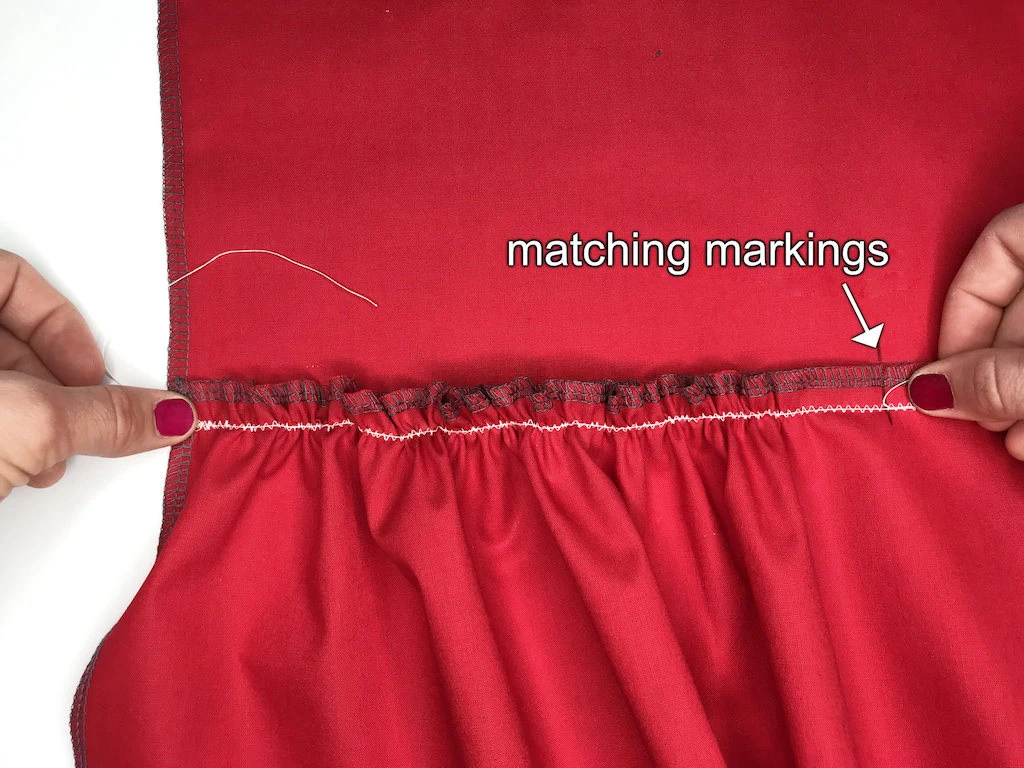 Comparing asegment of gathered fabric with a fabric to which it is going to be sewn.