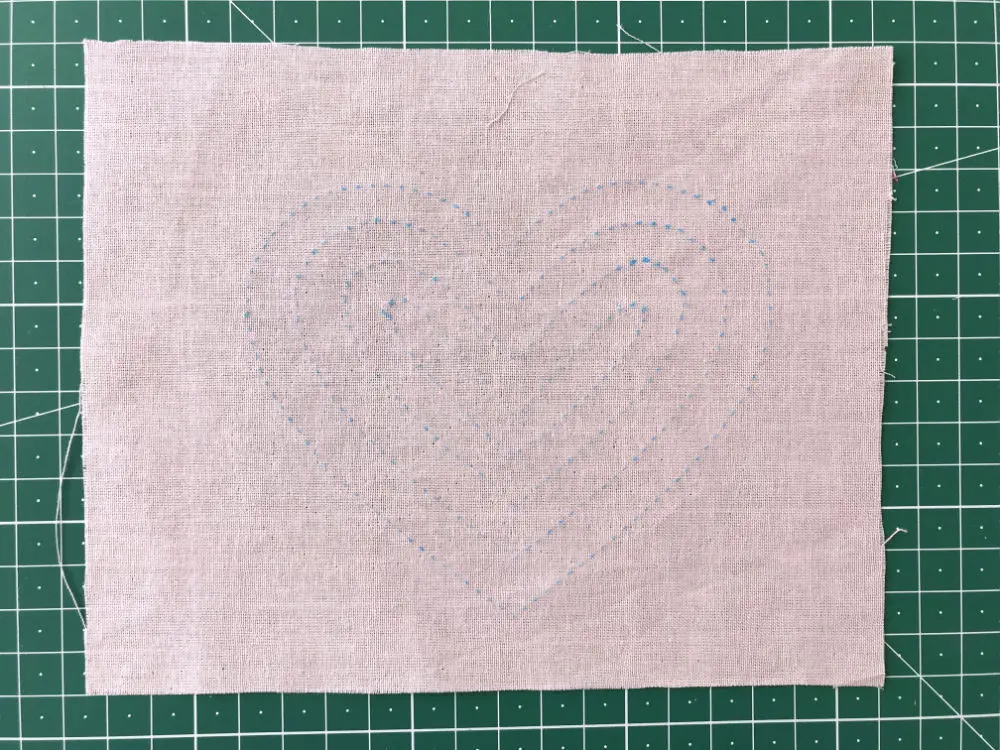 Heart template transferred to pink cotton fabric using a dressmakers tracing paper and tracing wheel.