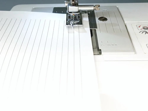 Unthreaded sewing machine prepared for sewing sewing practice sheets.