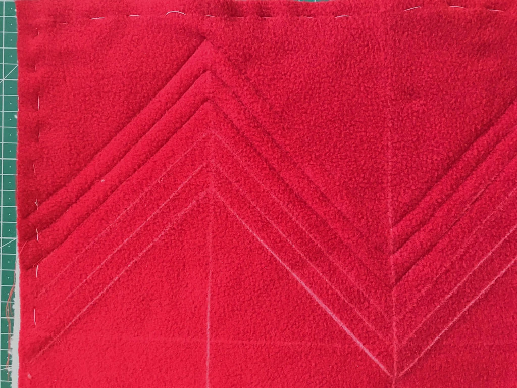 Sewn and drawn diagonal lines on a faux chenille style christmas pillowcase.