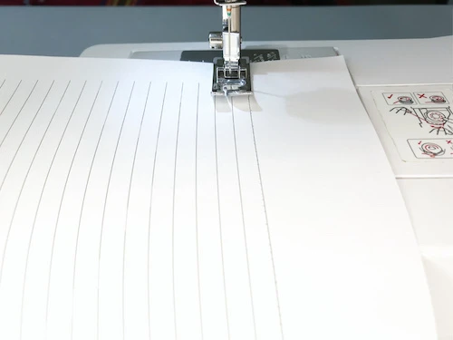 Sewing slightly curved lines using a sewing machine practice sheet.