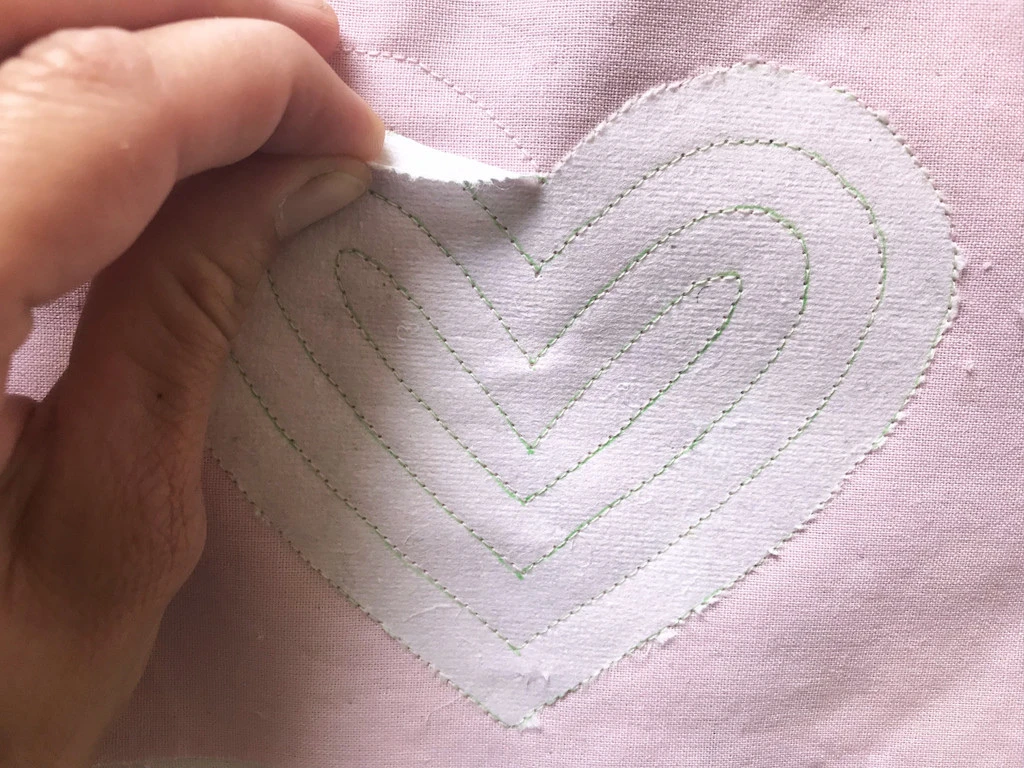 Tearing off the stabiliser from cotton fabric.