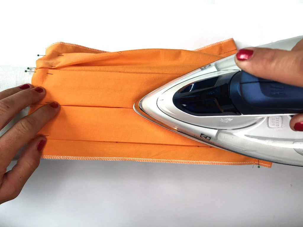 Pressing box pleats with an iron.