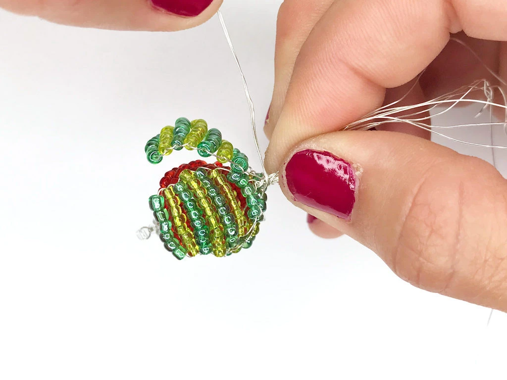Forming a top of an earring by twisting a wires together.